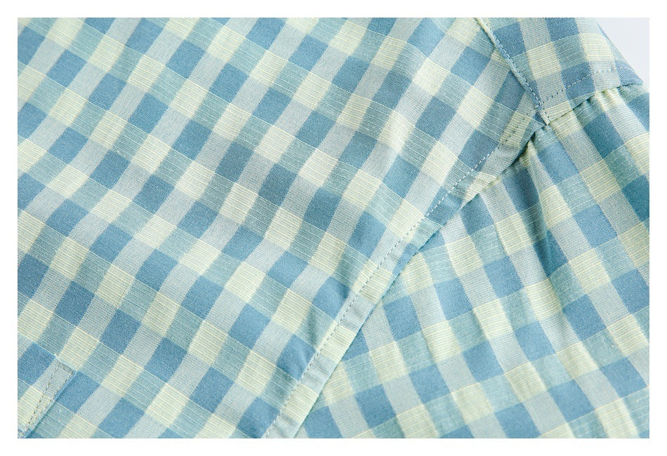 Close-up of a blue and pale yellow gingham shirt seam where the sleeve joins the body.