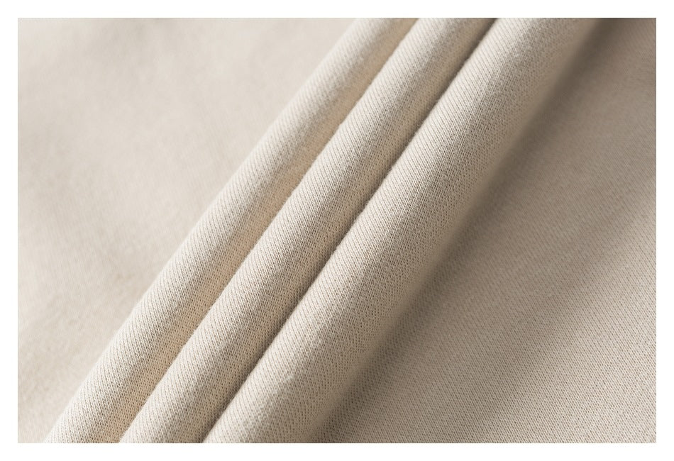 Close-up of beige fabric folded into soft ridges, showing its surface texture.