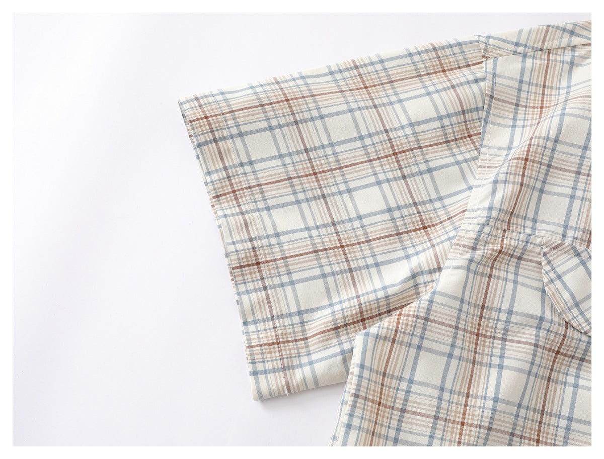 Close-up of the plaid shirt sleeve and cuff edge beside the body.