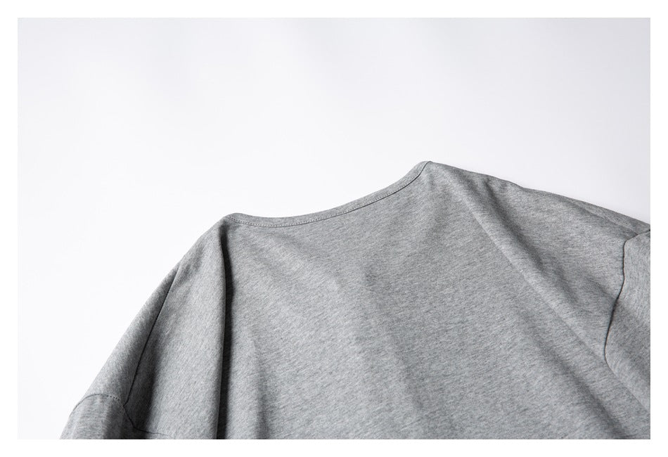 Close-up of the back neckline and shoulder seams of a heather-gray shirt.