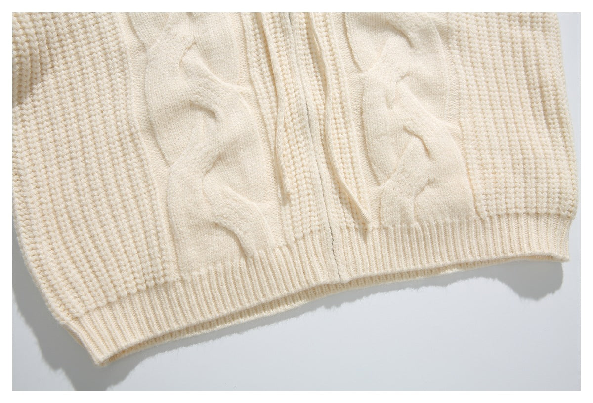 Close-up of the ivory cardigan's cable-knit front and ribbed bottom hem.