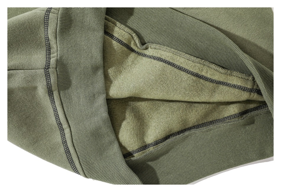 Close-up of the hoodie’s brushed interior fleece and ribbed hem with contrasting overlock stitching.