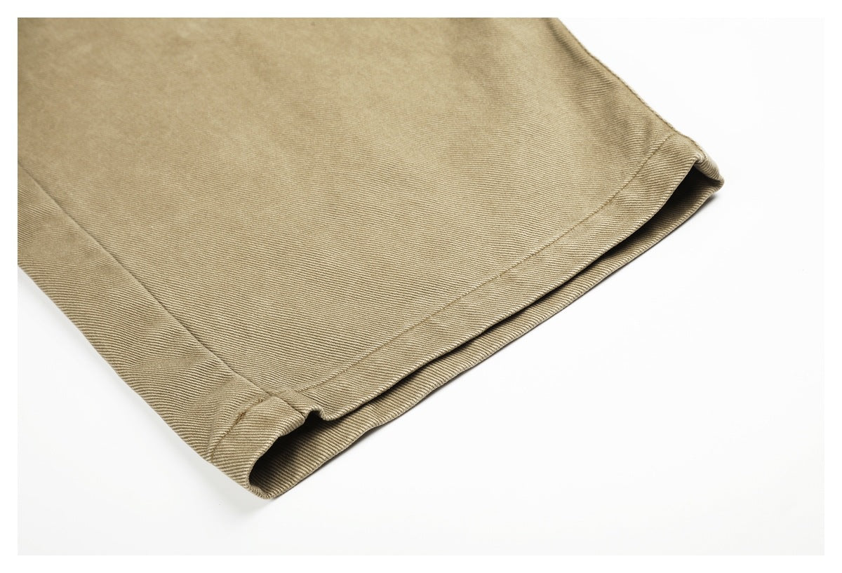Close-up of the stitched hem and folded edge of a khaki trouser leg.