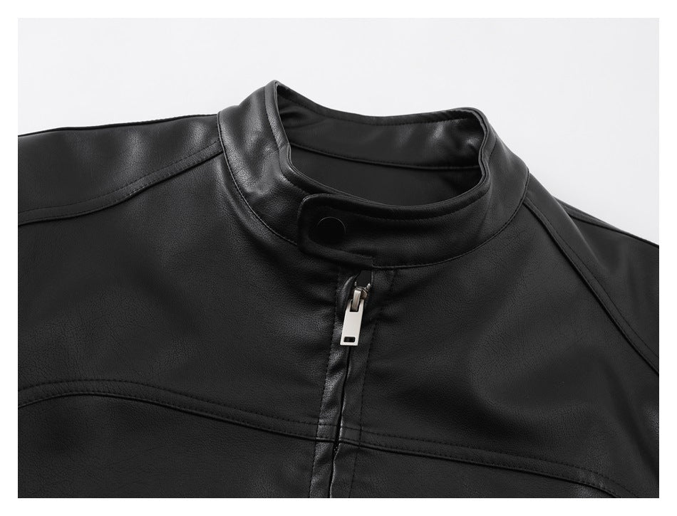 Close-up of a black jacket’s stand collar, snap tab, front zipper, and stitched panels.