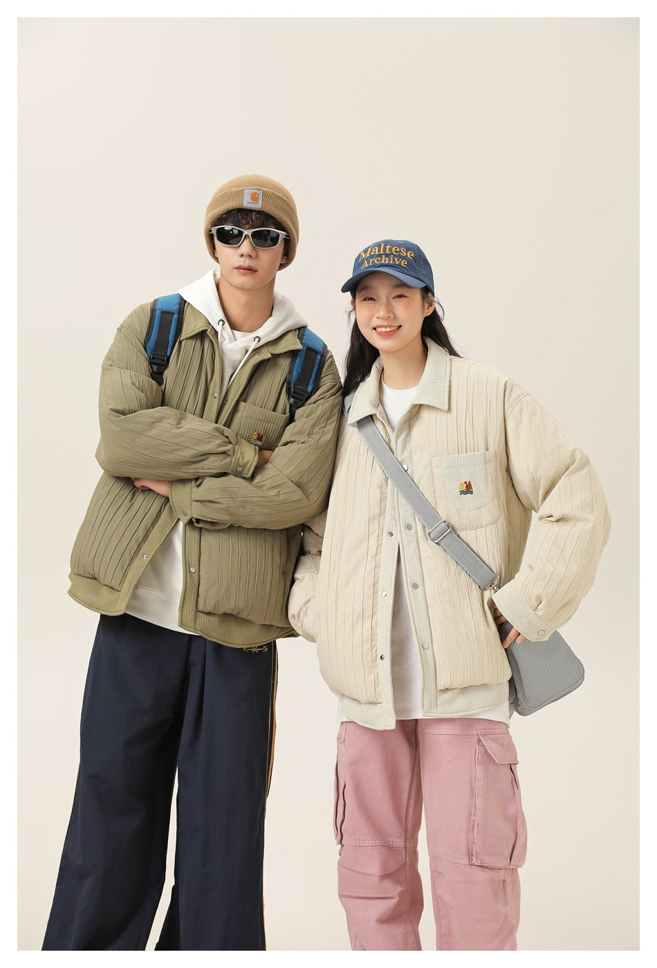 Two models wear olive and cream quilted button-front jackets with chest pockets; the woman wears a blue cap.