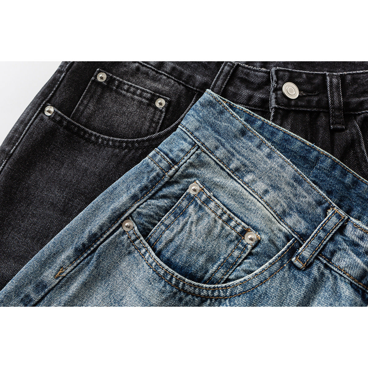 Close-up of black and faded blue jeans showing front pockets, waistbands, belt loops, and metal rivets.