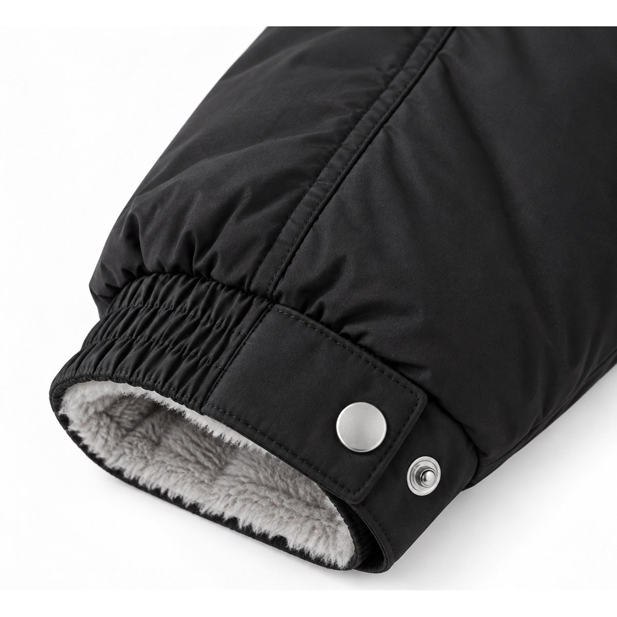 Close-up of a black jacket cuff with elastic gathering, snap tab and visible white fleece lining.