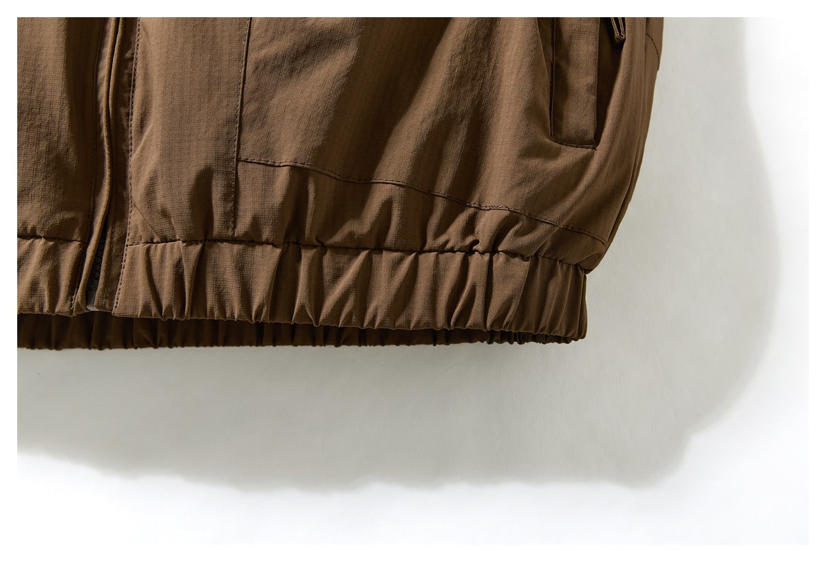 Close-up of the brown vest's gathered elastic hem and lower panel seam.