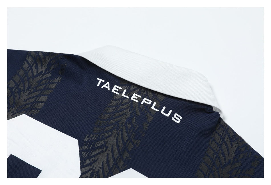 Close-up of a navy garment collar with a white collar and white “TAELEPLUS” lettering over a dark patterned print.