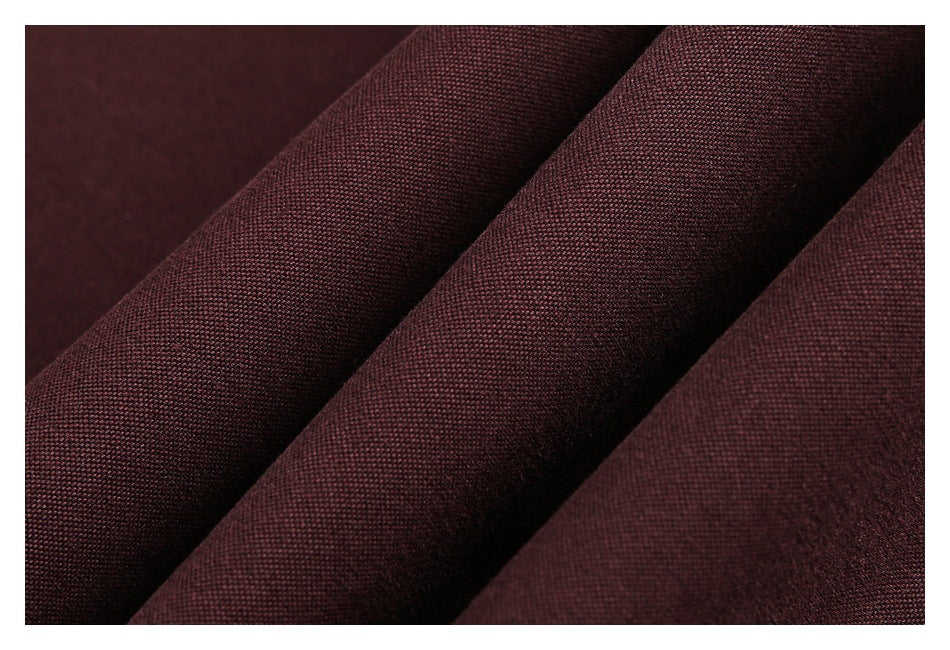 Macro view of burgundy fabric draped in folds, showing its fine woven texture.