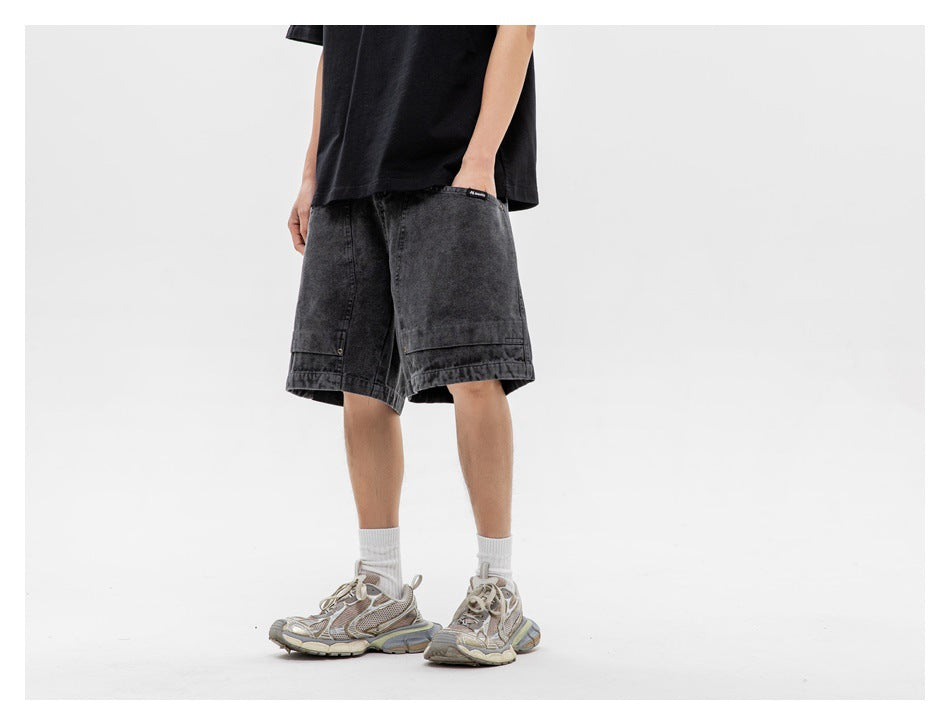 Cropped view of a person wearing charcoal utility shorts with a black T-shirt, white socks, and sneakers.