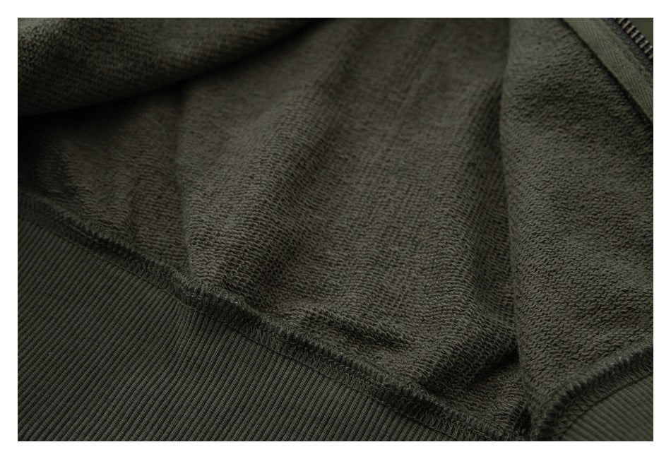 Close-up of the dark olive garment's textured inner fabric and ribbed seam.