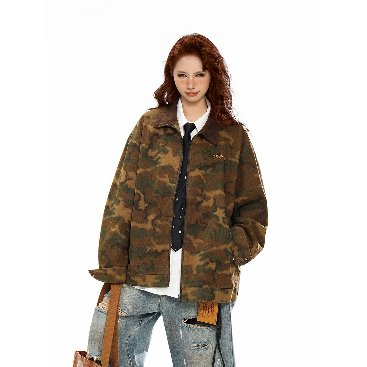 Model wearing an oversized brown and olive camouflage zip jacket with a dark collar and small chest embroidery.