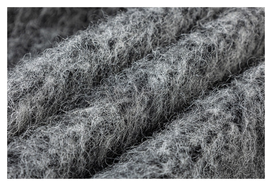 Extreme close-up of the shaggy gray garment fabric texture.