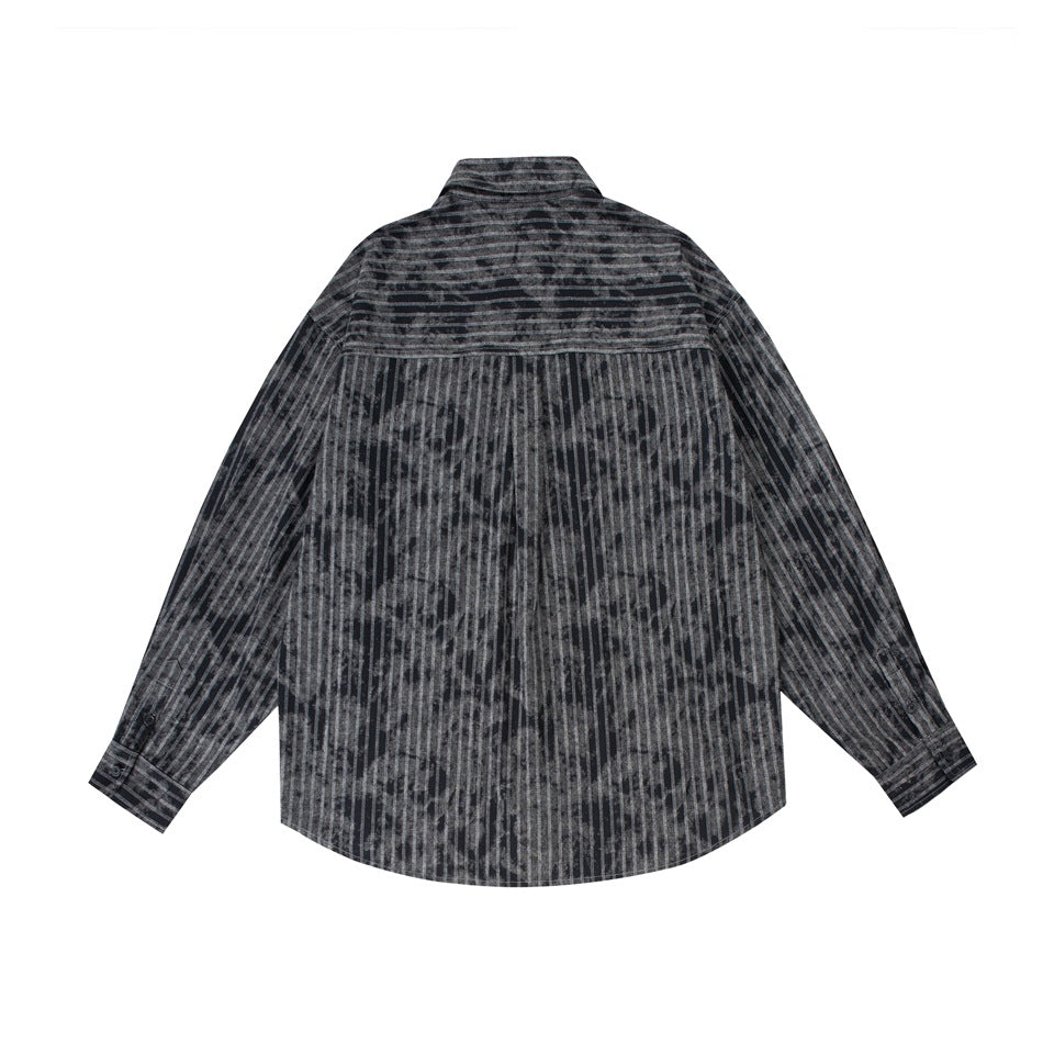 Back view of a charcoal shirt with vertical distressed stripes, long sleeves, a yoke, and a curved hem.