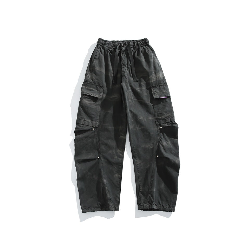 Front view of black cargo pants with an elastic drawstring waist, large side pockets and elastic cuffs.