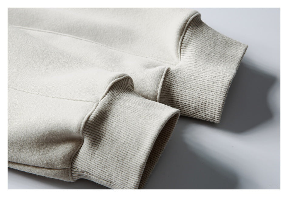 Cream sweatshirt sleeves with wide ribbed cuffs, shown against a pale background.