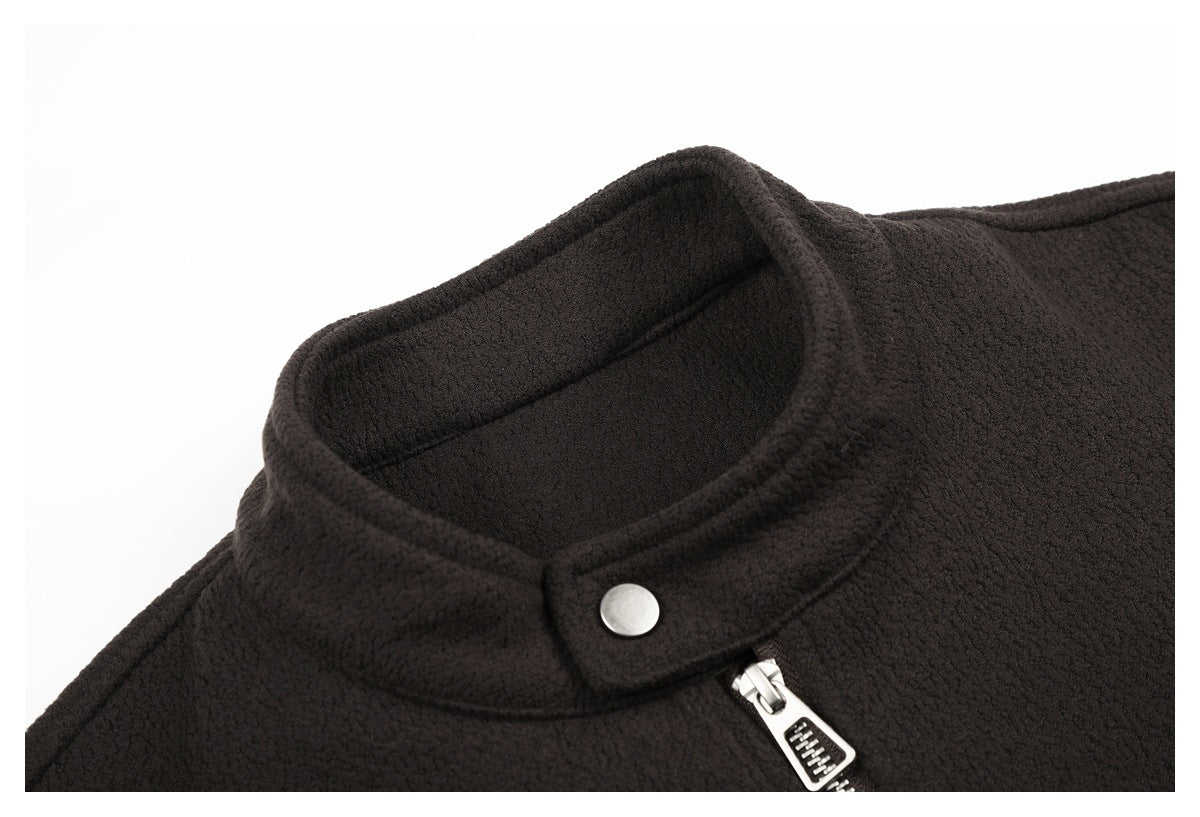 Close-up of a dark brown jacket's stand collar, silver snap, and zipper pull.