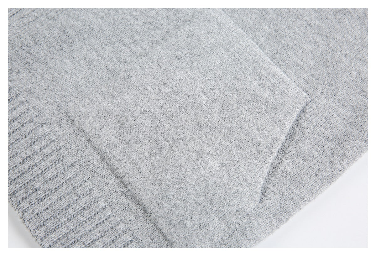 Light gray knit garment close-up showing a ribbed edge and curved seam.