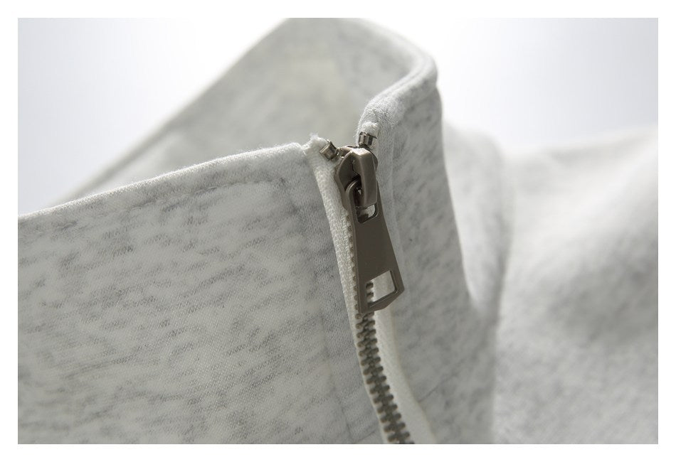 Close-up of the metal zipper and collar on a light gray heathered sweatshirt.