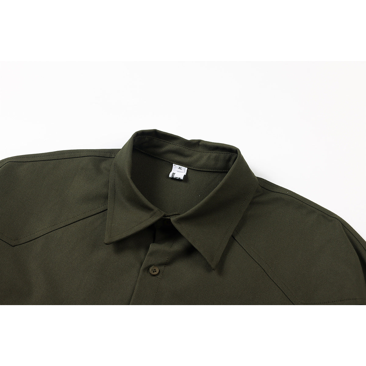 Close-up of a dark olive shirt collar, shoulder yoke, front button, and small neck size label.
