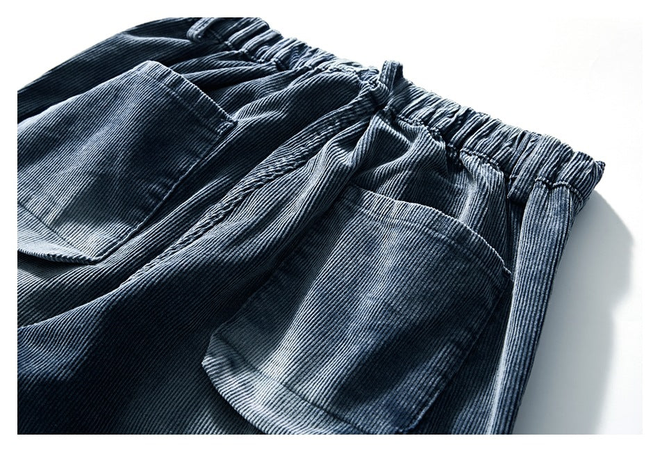 Blue-gray corduroy pants shown close-up, with a gathered waistband and two front pockets.