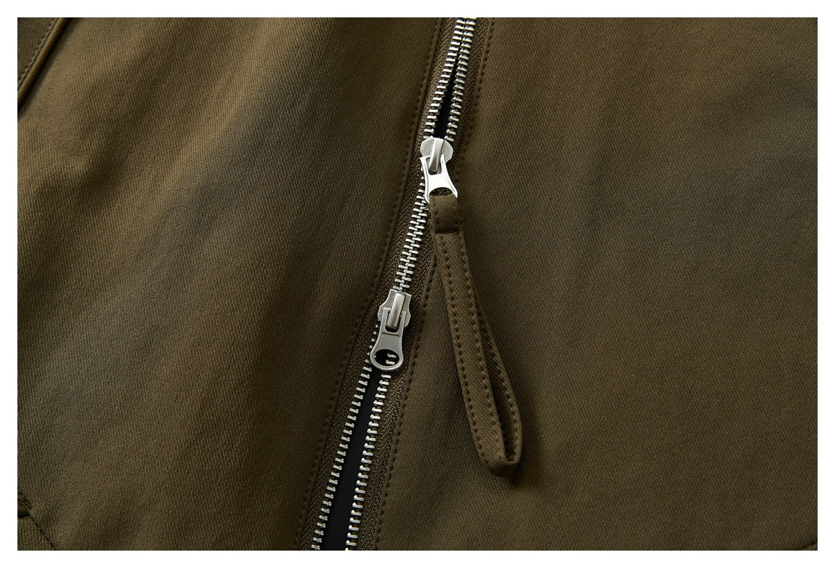 Close-up of the olive-brown jacket's silver two-way zipper and fabric pull tabs.