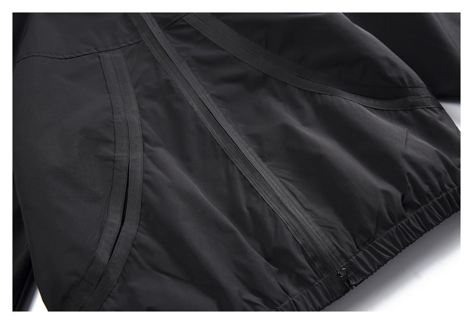 Close-up of curved black jacket trim and the gathered elastic hem.