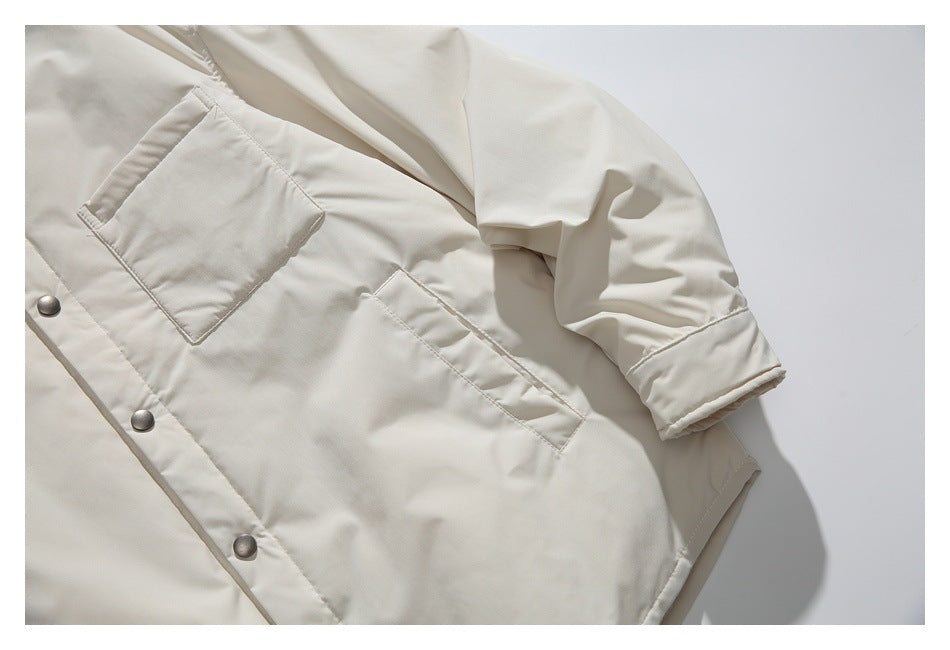 Close-up of an ivory jacket’s snap-front placket, chest pocket, and gathered sleeve.