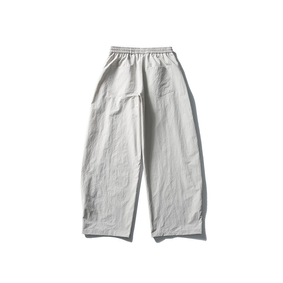 Back view of light gray relaxed, wide-leg pants with an elastic waistband and two rear patch pockets.