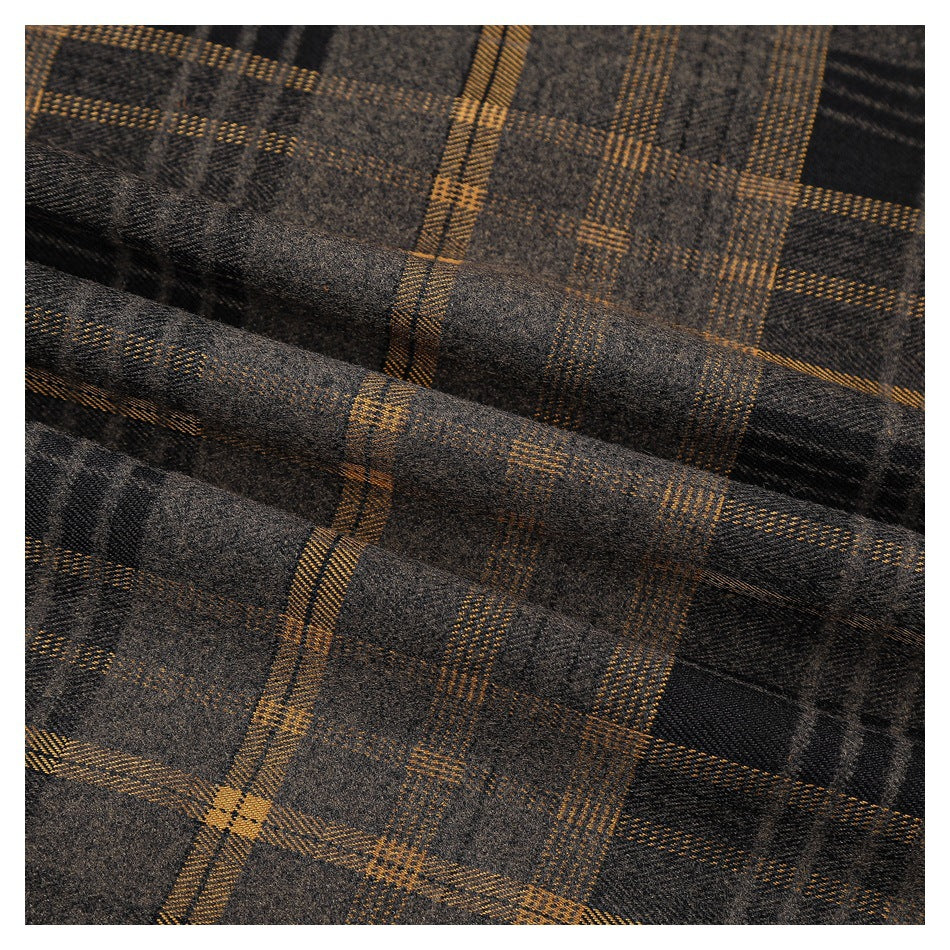 Close-up of gray-brown plaid fabric with mustard and black checks, shown in soft folds.