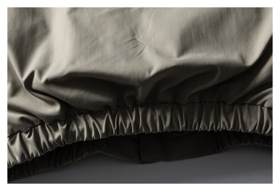 Close-up of a taupe-gray garment's gathered elastic edge and stitching.