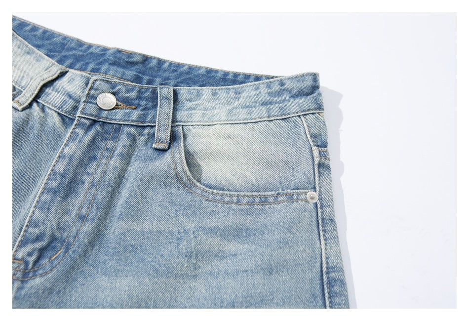 Close-up of the light-wash jeans' front button, fly stitching, belt loop and curved pocket.