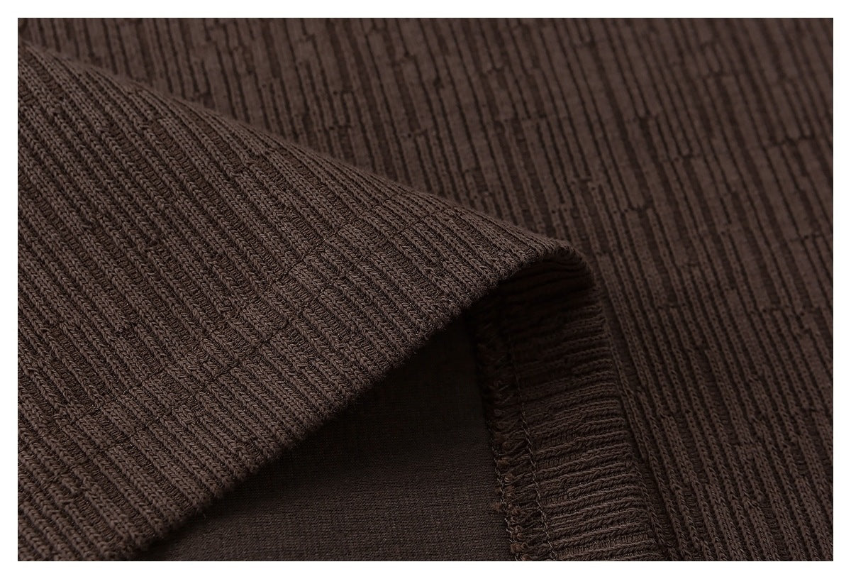 Close-up of a folded edge and seam on the brown ribbed garment.