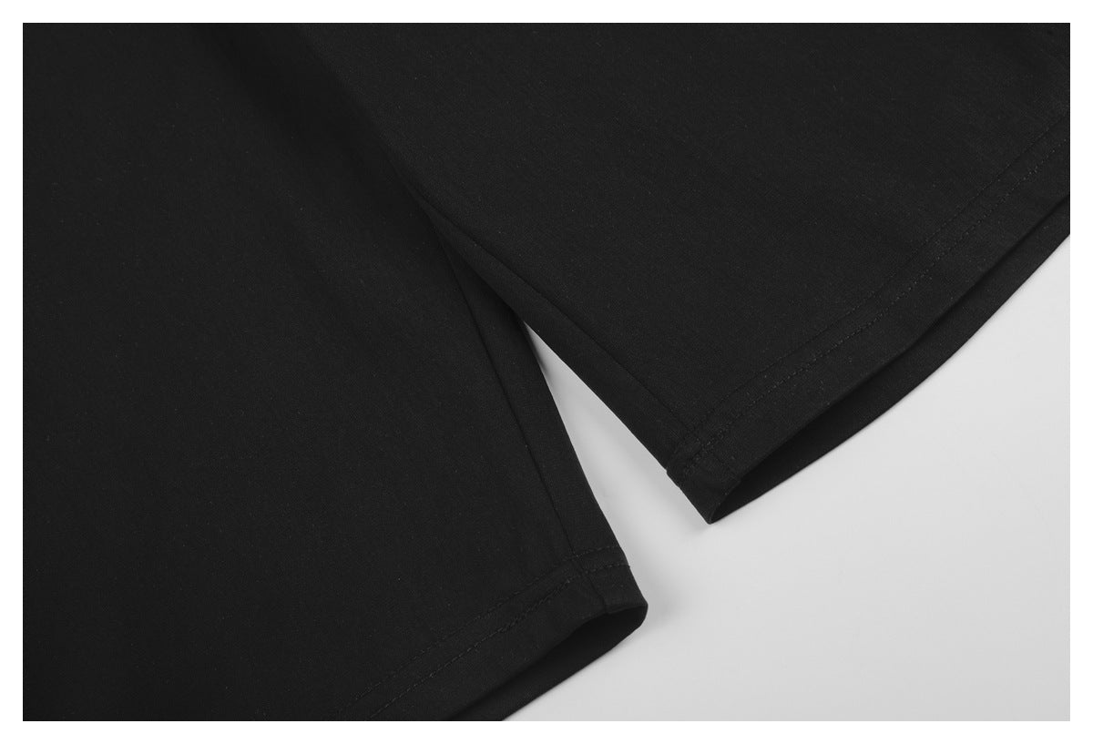 Close-up of the stitched hems on black trouser legs.