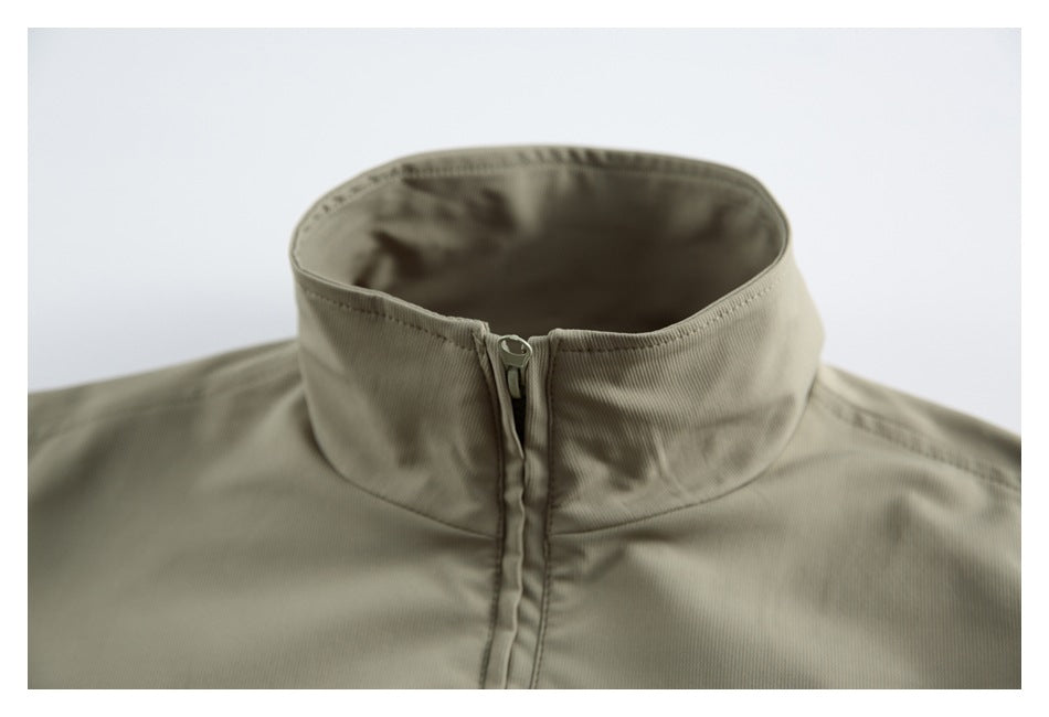 Close-up of an olive-gray jacket's stand collar and front zipper.