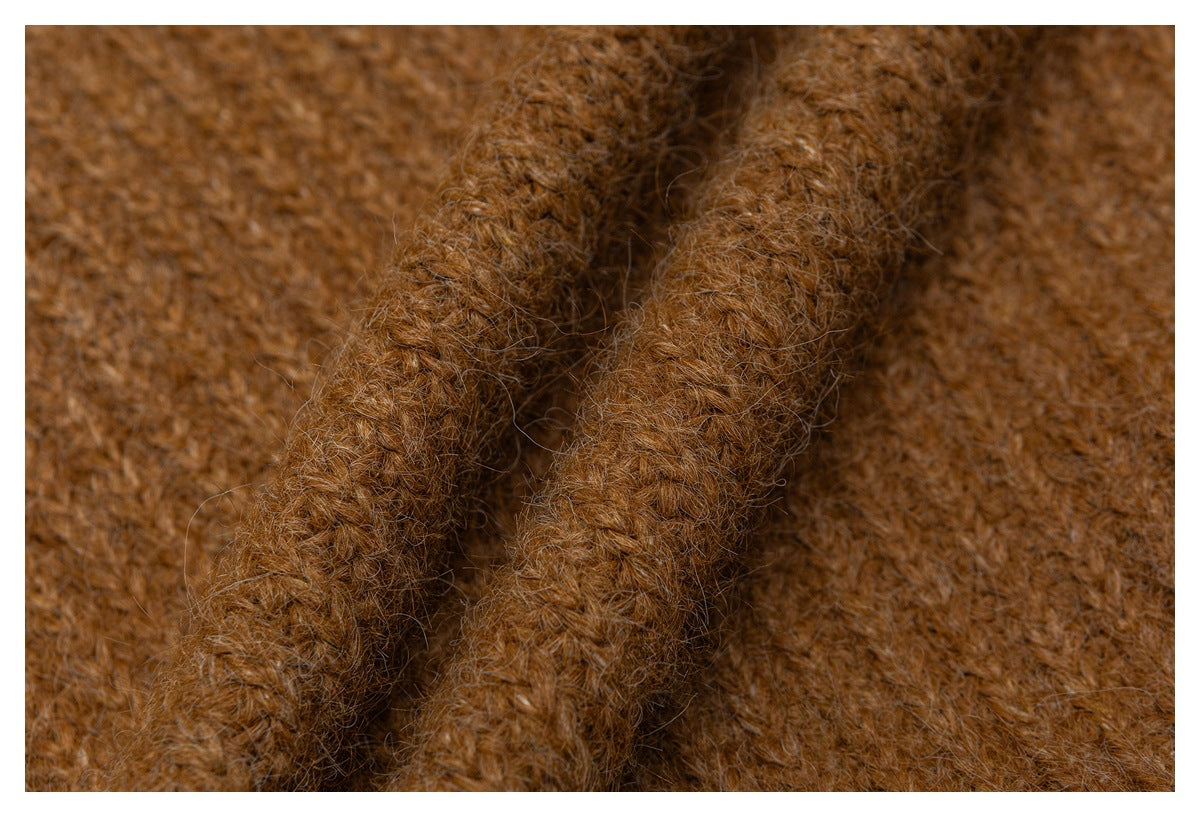 Close-up of two raised knitted edges against the brown garment's textured surface.