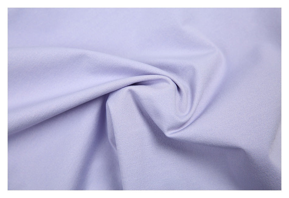 Close-up of pale lavender fabric gathered into a soft fold, showing its smooth surface.