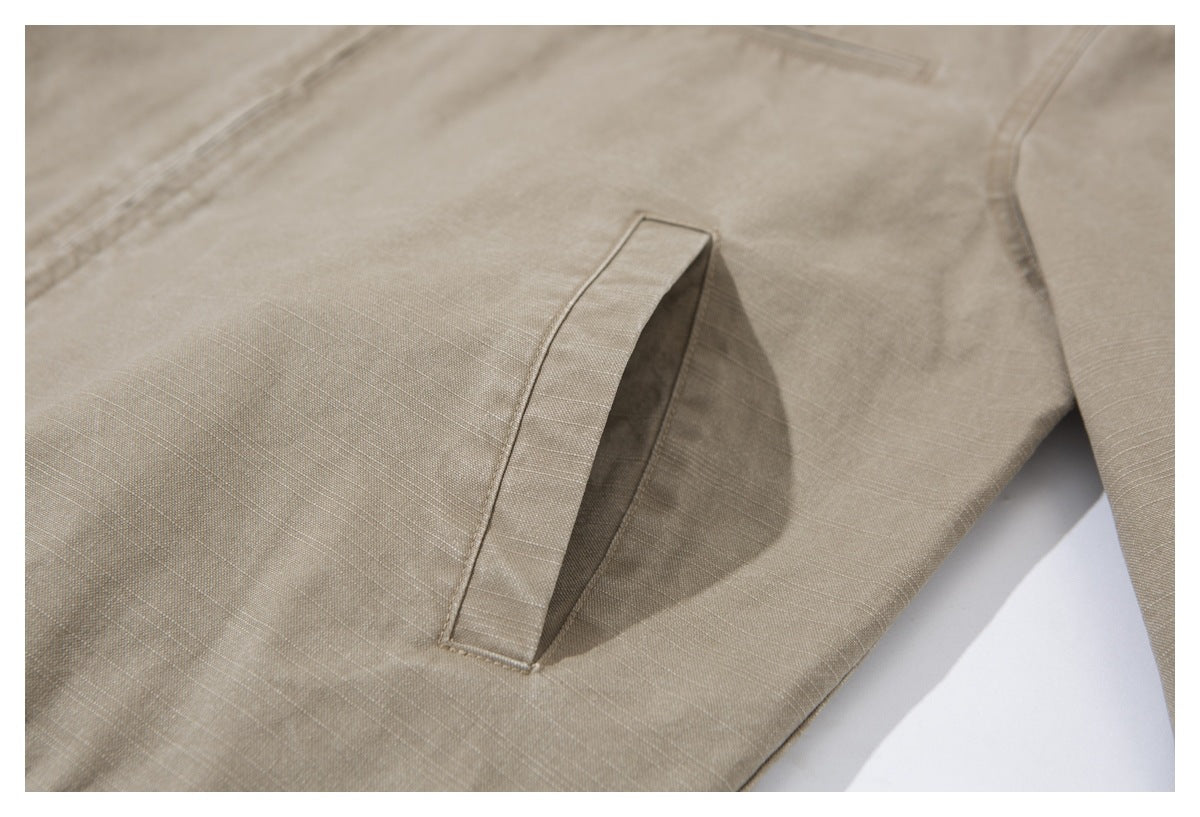 Close-up of a slanted welt pocket on the taupe jacket.