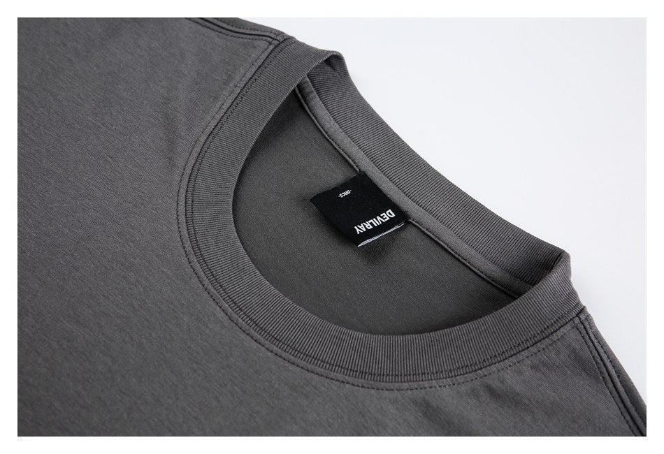 Close-up of the charcoal garment’s ribbed crew neckline and sewn-in black neck label.