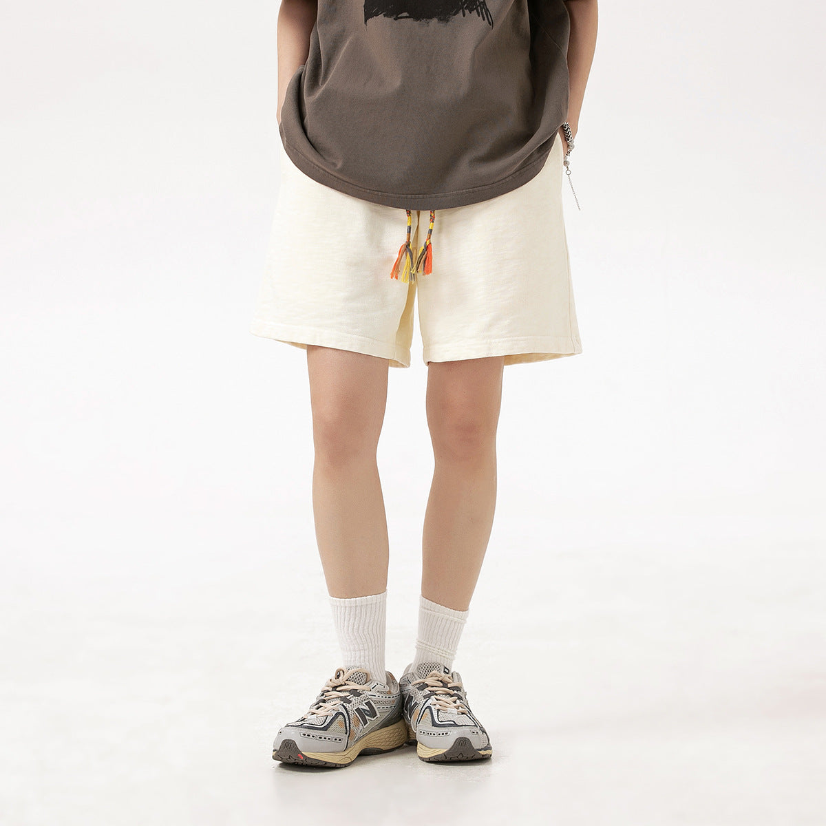 Model wearing off-white shorts with a colorful braided drawstring and tassels.