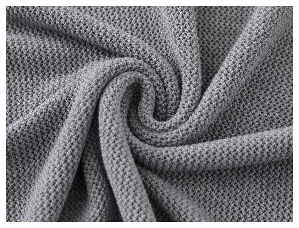 Close-up of the gray sweater's textured knit draped into soft folds.