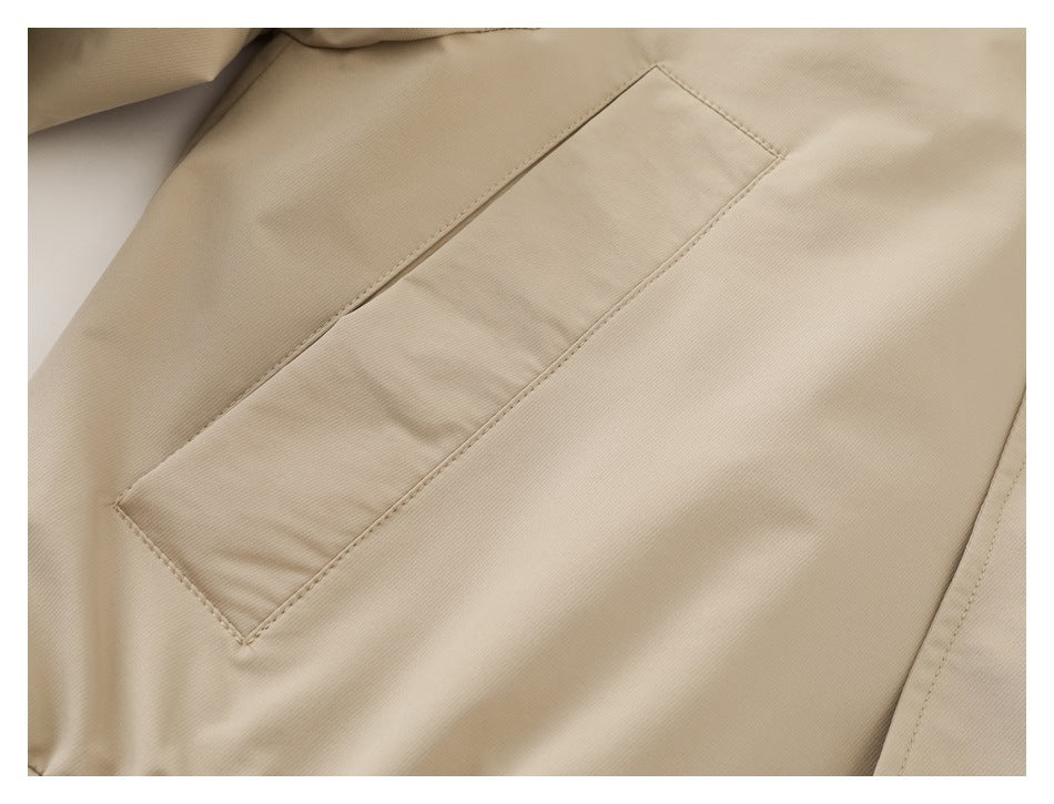 Close-up of a rectangular welt pocket on a beige jacket.