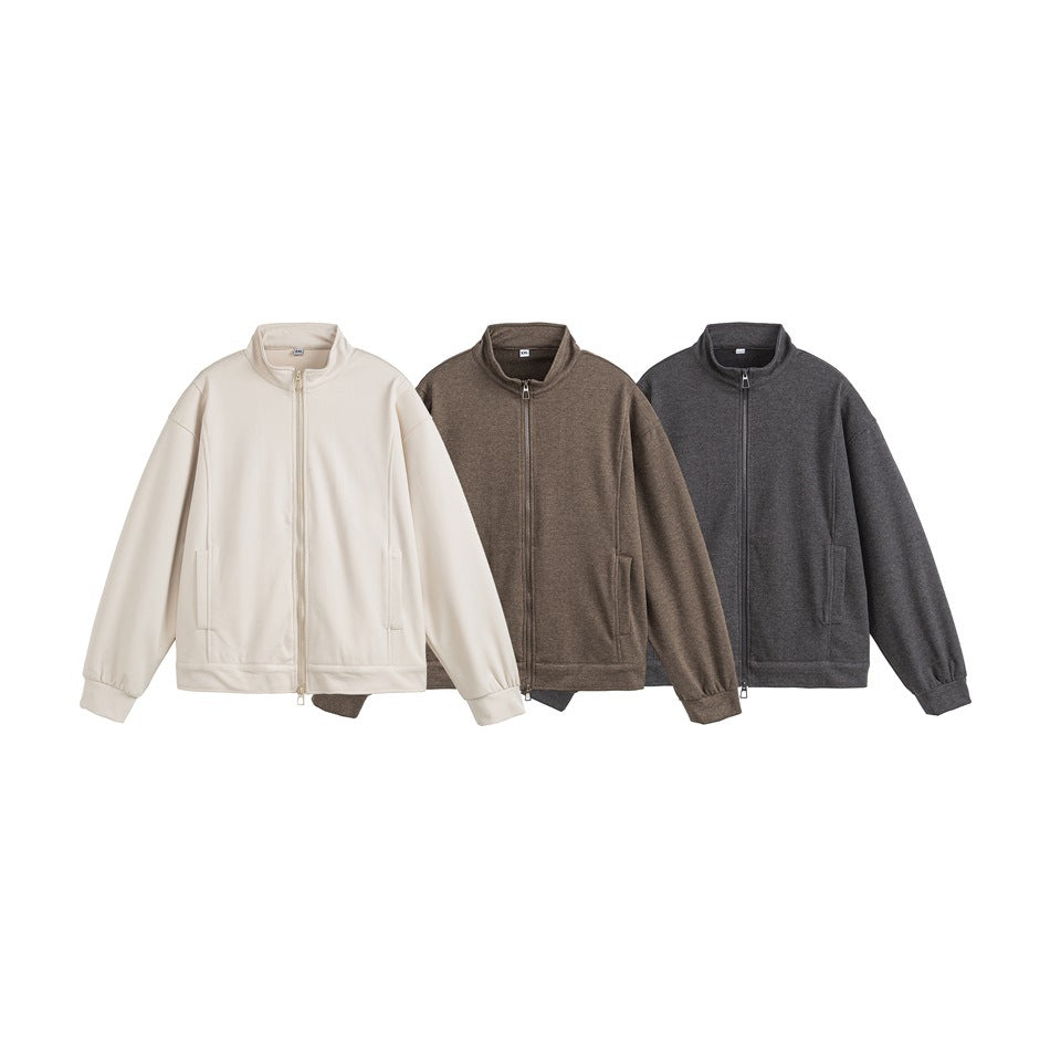 Three stand-collar zip jackets displayed together in off-white, brown, and charcoal.