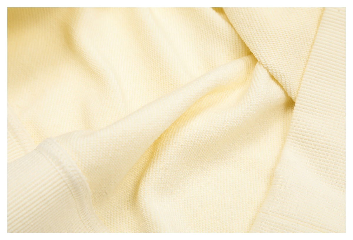 Close-up of cream knit fabric and a ribbed garment edge.