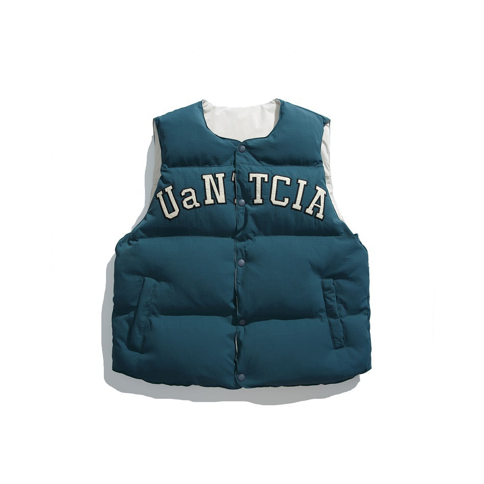 Teal puffer vest with snap front, front pockets and cream arched letter patch, off-white inner side visible at neckline