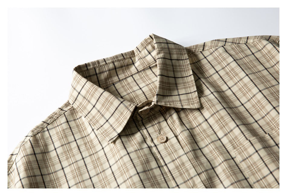 Close-up of a beige plaid short-sleeve shirt collar, button placket, and upper chest.