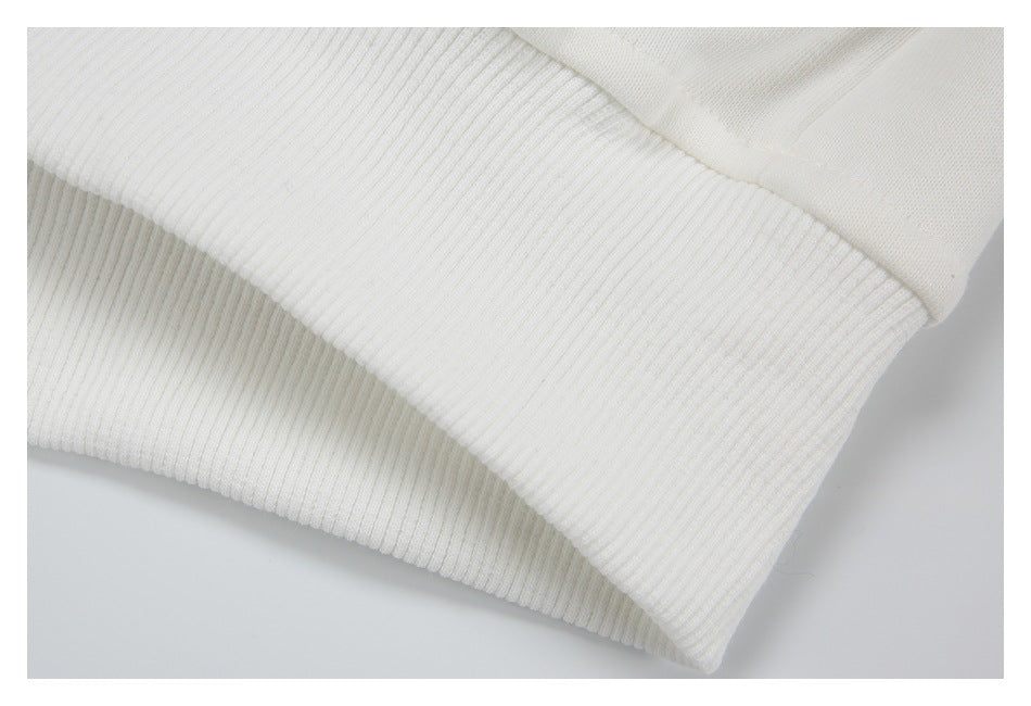 Close-up of a wide ribbed white garment hem joined to smooth fabric.