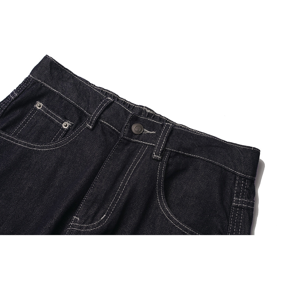 Close-up of dark indigo jeans showing the front waistband, button, belt loops and front pockets with contrast stitching.