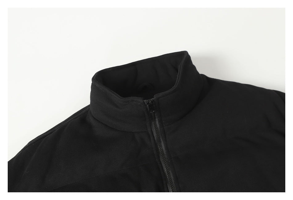 Close-up of a black garment's raised stand collar and front zipper.